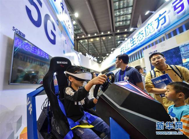  11月19日，参观者在中国移动的展台体验5G驾驶游戏。当日，在深圳举行的第十九届中国国际高新技术成果交易会上，各大运营商设立的5G展台吸引参观者的目光。新华社记者毛思倩摄 