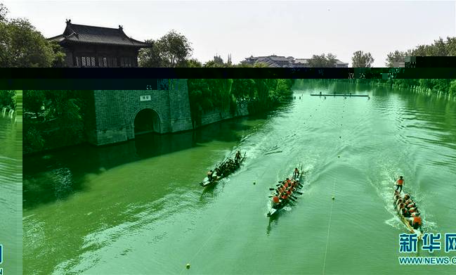 6月7日，人们在山东省枣庄市台儿庄古城古运河道上划龙舟。 新华社发（高启民摄）